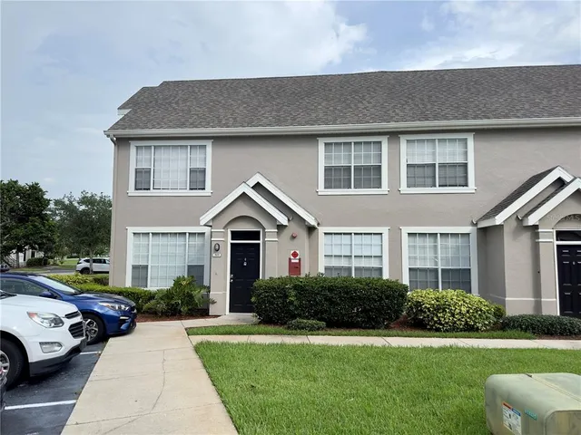 a front view of a house with a garden and trees