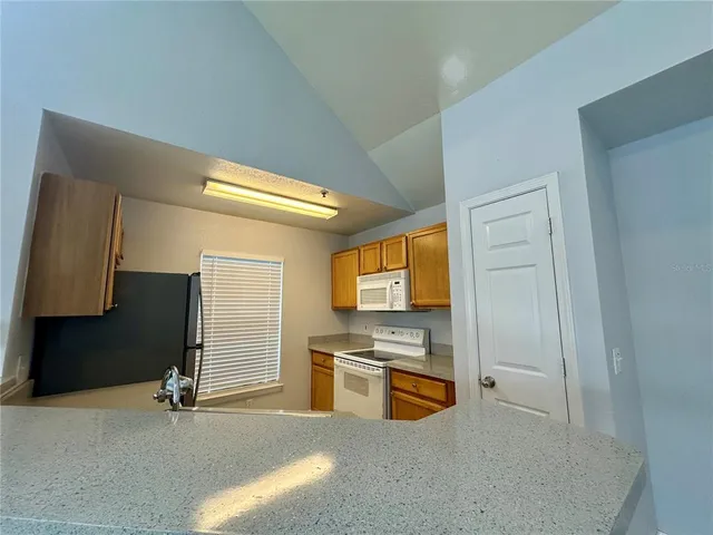 a view of a kitchen with stainless steel appliances a refrigerator