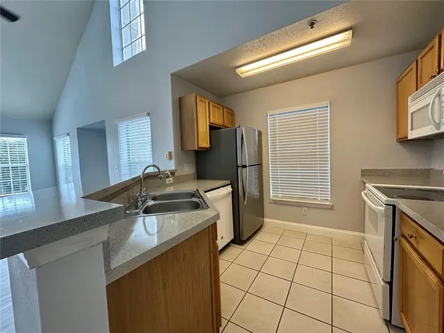 a kitchen with a sink a stove cabinets and a kitchen