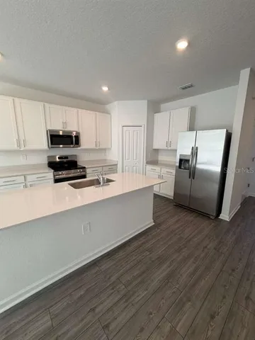 a kitchen with stainless steel appliances a refrigerator sink and microwave