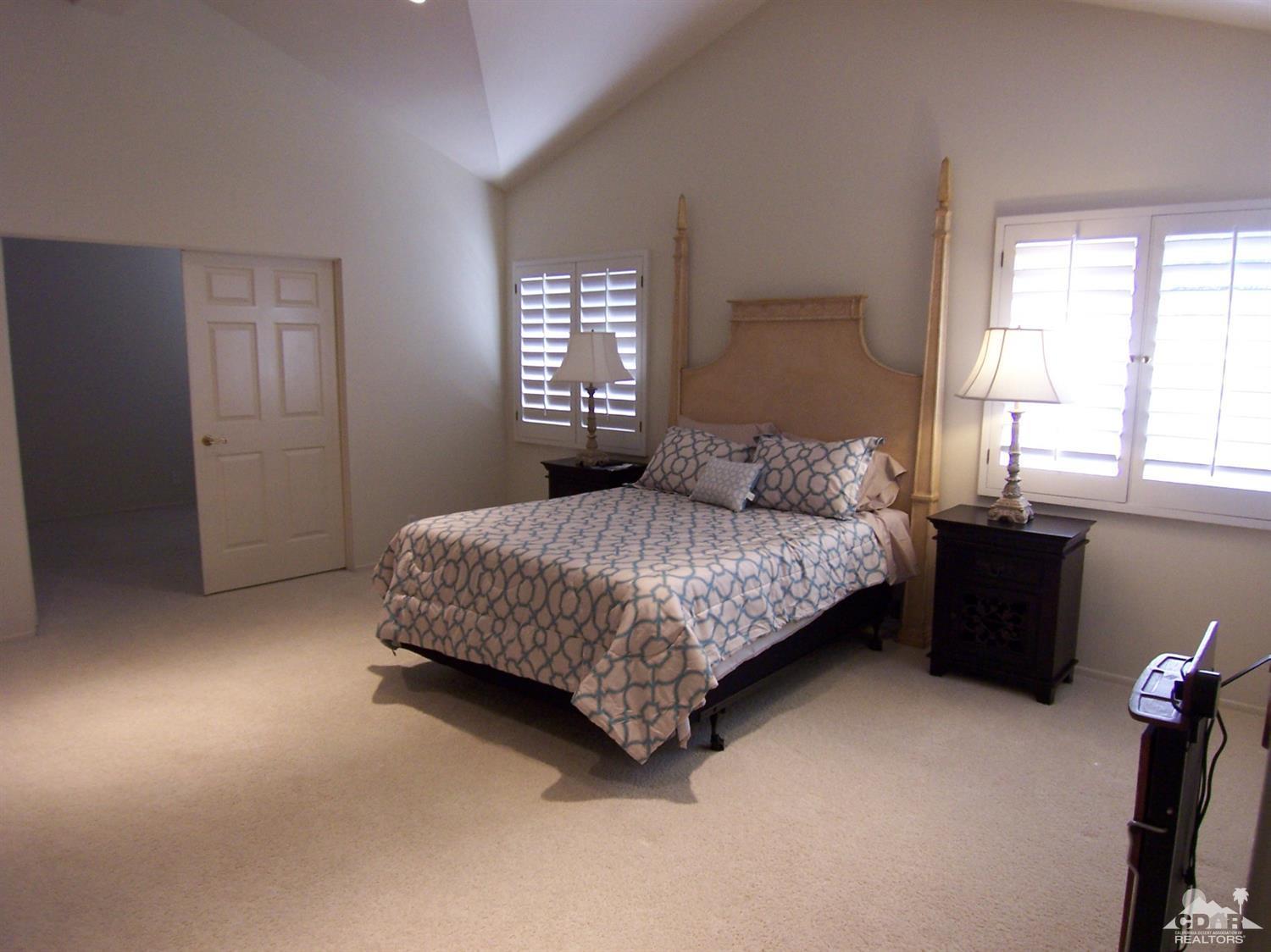 195 Desert Lakes Drive Rancho Mirage, CA 92270 - Photo 15 of 28 a bedroom with a bed and a window