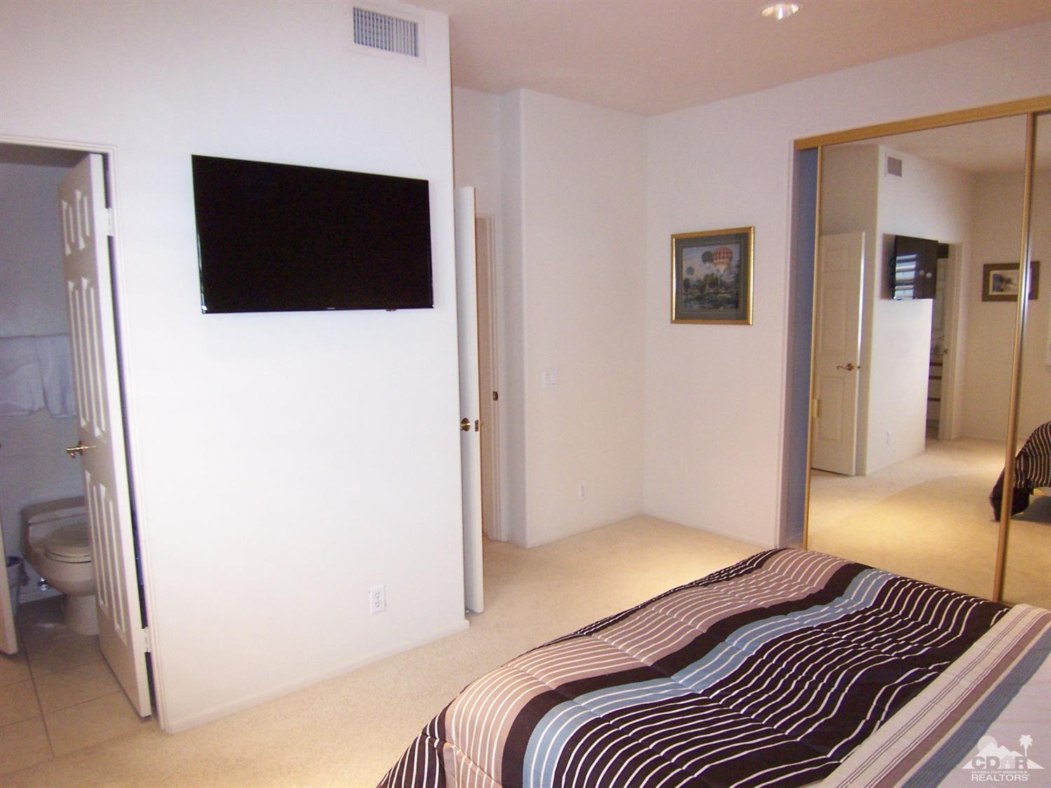 195 Desert Lakes Drive Rancho Mirage, CA 92270 - Photo 17 of 28 a bedroom with a bed and a view of bathroom