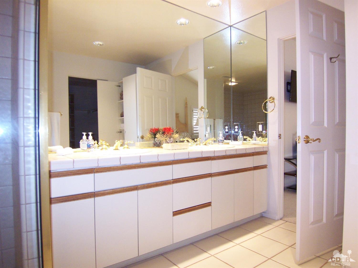 195 Desert Lakes Drive Rancho Mirage, CA 92270 - Photo 18 of 28 a bathroom with a sink and a mirror