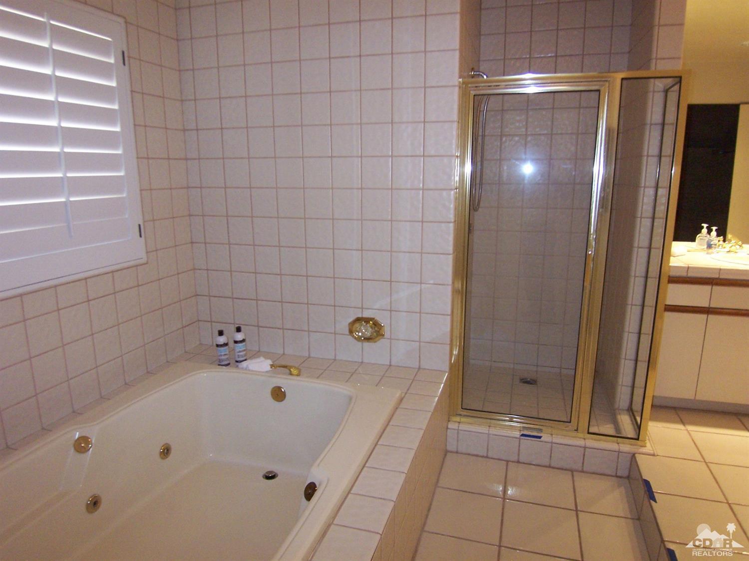 195 Desert Lakes Drive Rancho Mirage, CA 92270 - Photo 20 of 28 a bathroom with a bathtub and shower