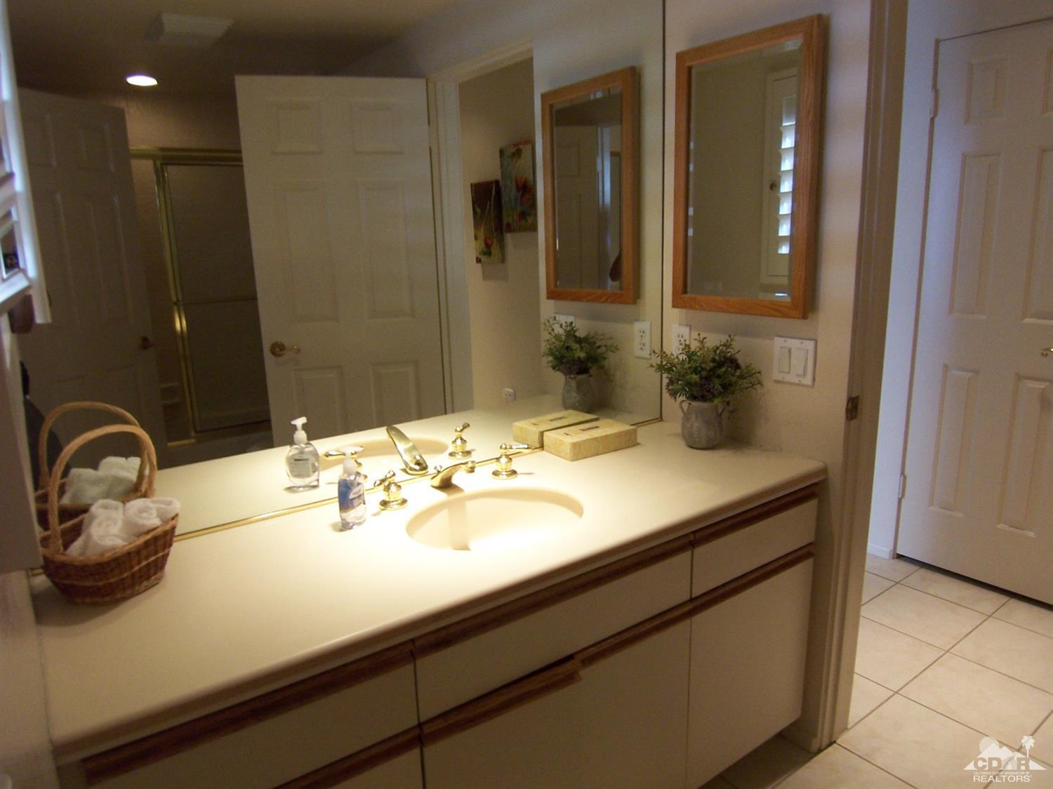 195 Desert Lakes Drive Rancho Mirage, CA 92270 - Photo 21 of 28 a bathroom with a sink and a mirror