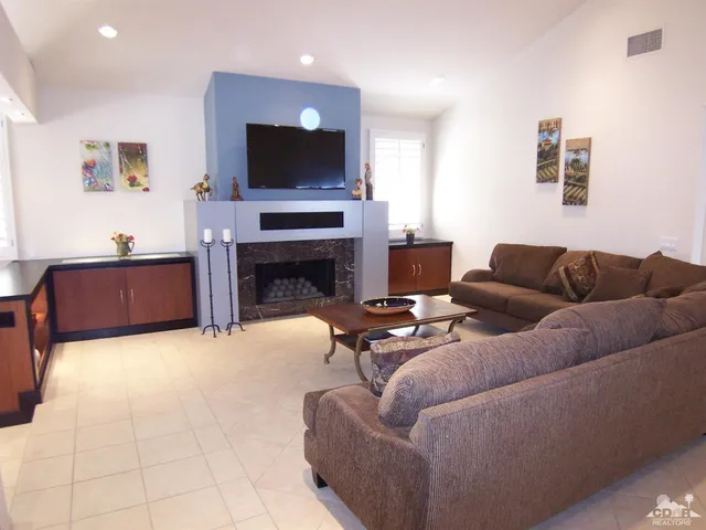 a living room with furniture a flat screen tv and a fireplace