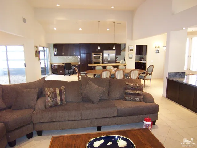 a living room with furniture kitchen and a flat screen tv