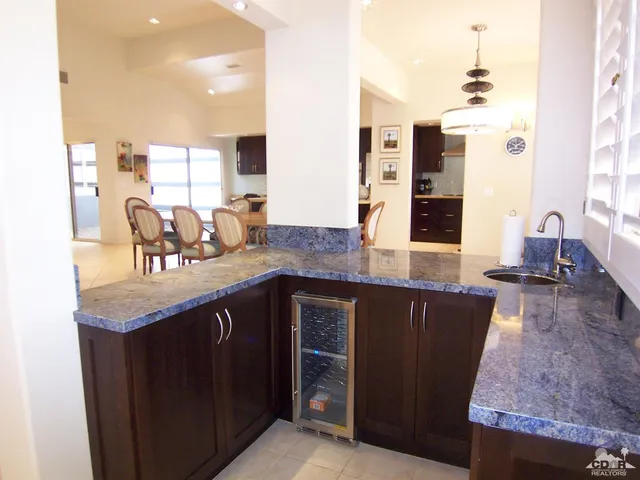 a kitchen with granite countertop a sink and cabinets