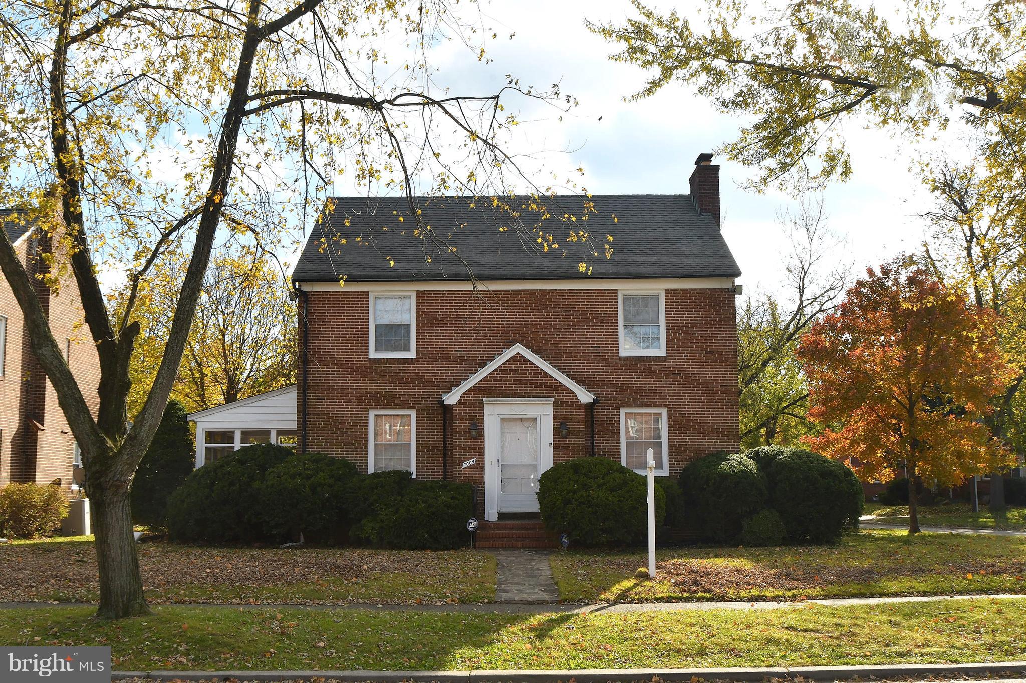 7009 Mornington Road Dundalk, MD 21222 - Photo 2 of 48 a view of a brick house next to a yard with large trees