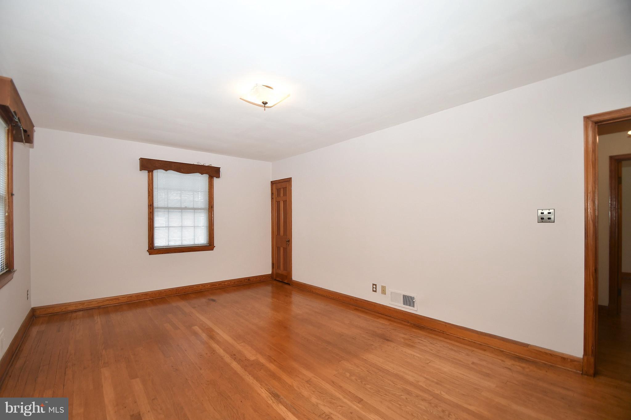 7009 Mornington Road Dundalk, MD 21222 - Photo 21 of 48 an empty room with wooden floor and windows
