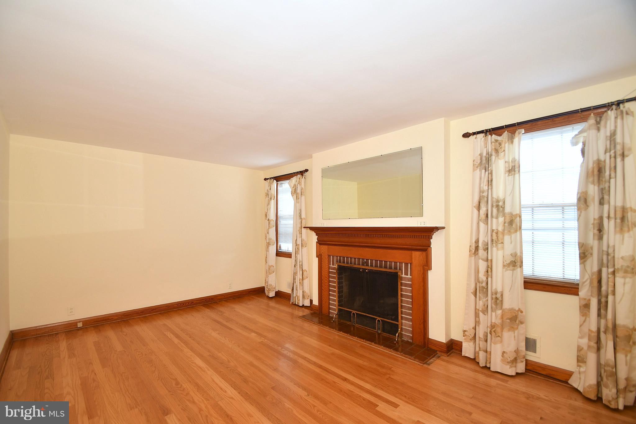 7009 Mornington Road Dundalk, MD 21222 - Photo 5 of 48 a view of empty room with wooden floor and fireplace