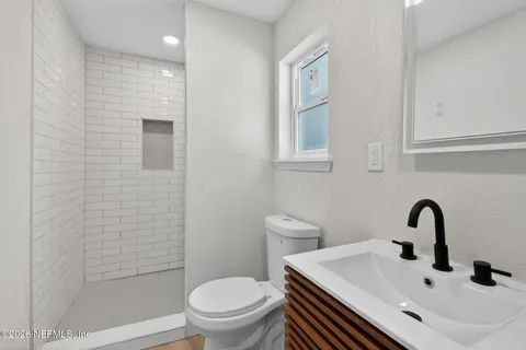 a bathroom with a sink a toilet and shower