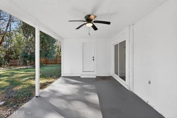 a view of empty room with window and ceiling fan