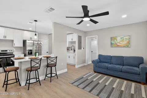 a living room with furniture and kitchen view