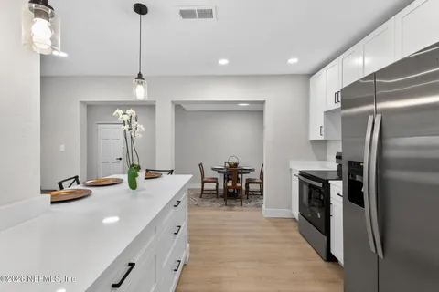 a kitchen with kitchen island a counter top space appliances and a ceiling fan