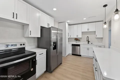 a kitchen with white cabinets and stainless steel appliances