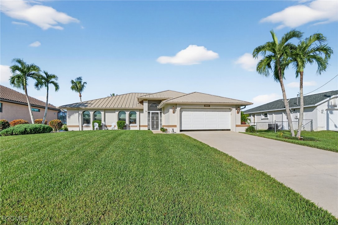 4306 Southwest 3rd Avenue Cape Coral, FL 33914 - Photo 2 of 50 a front view of a house with a garden and yard