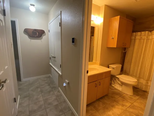 a bathroom with a granite countertop sink toilet and shower