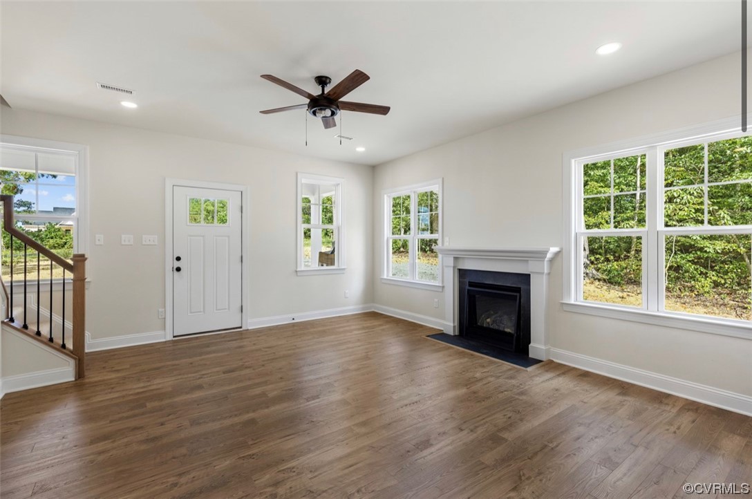 950 Kennon Road Bumpass, VA 23024 - Photo 5 of 26 an empty room with windows fireplace and wooden floor