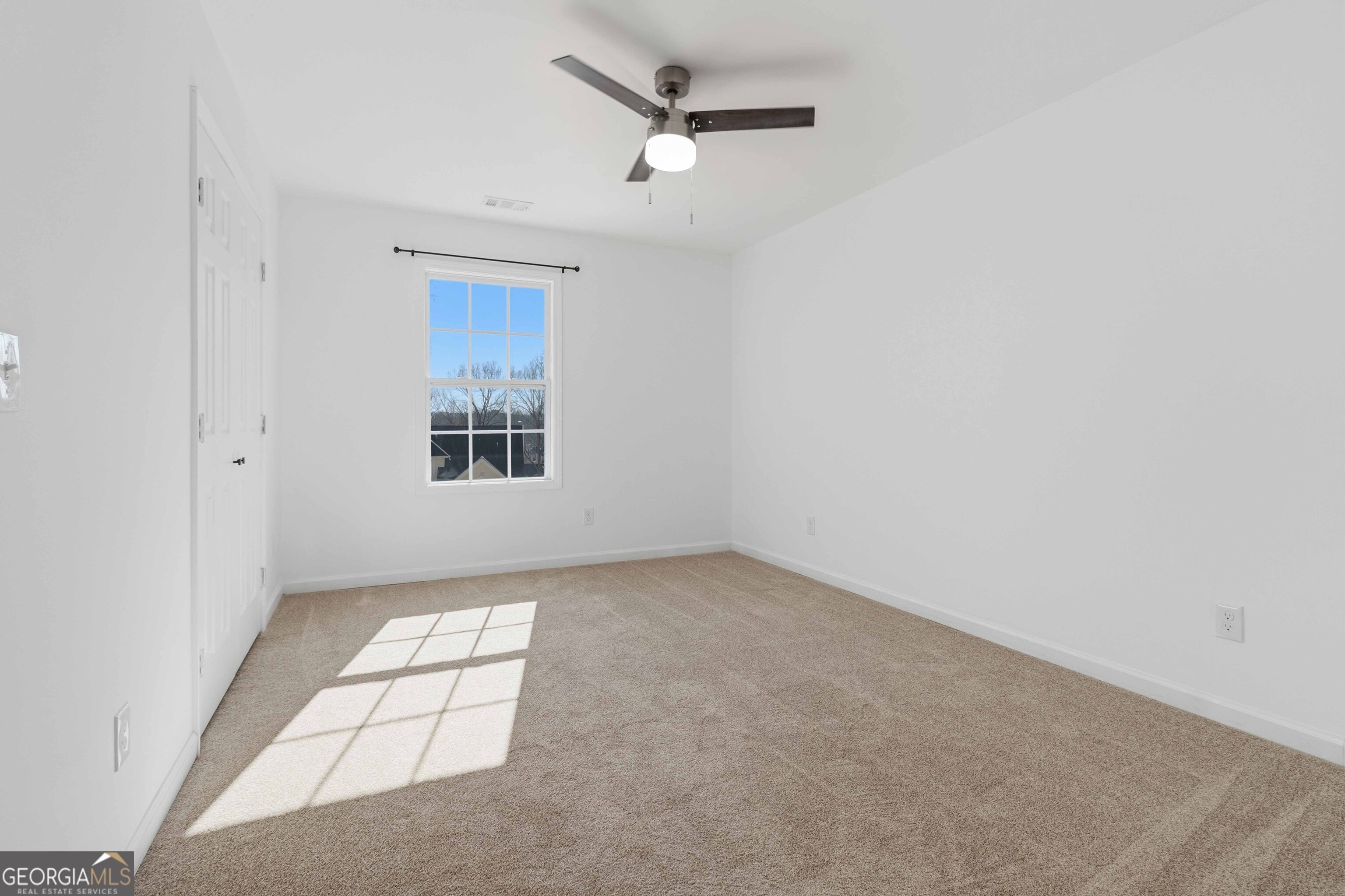 6938 Shadow Ridge Lane Stone Mountain, GA 30087 - Photo 15 of 27 an empty room with windows and ceiling fan