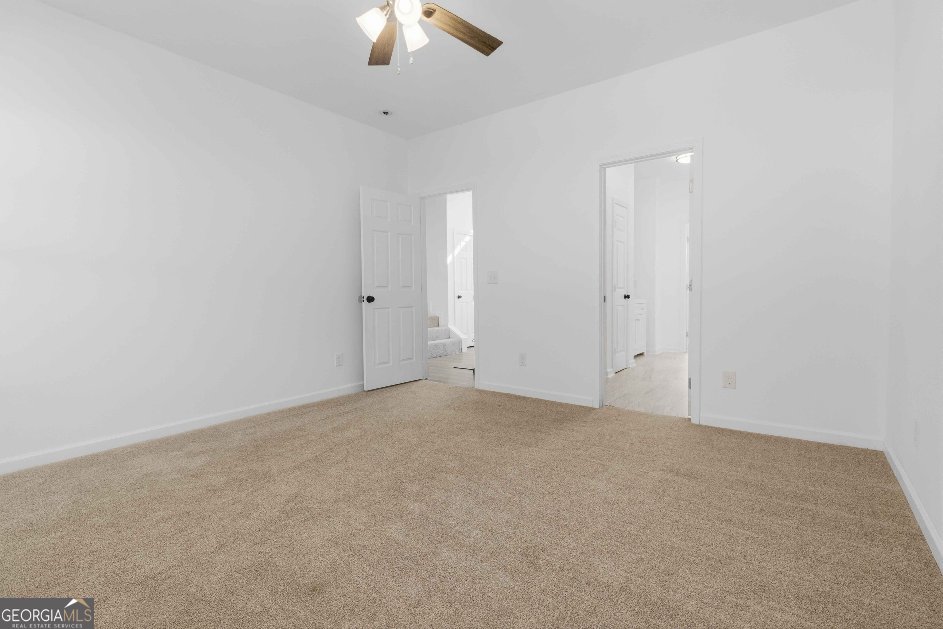 6938 Shadow Ridge Lane Stone Mountain, GA 30087 - Photo 25 of 27 an empty room with a chandelier fan and windows