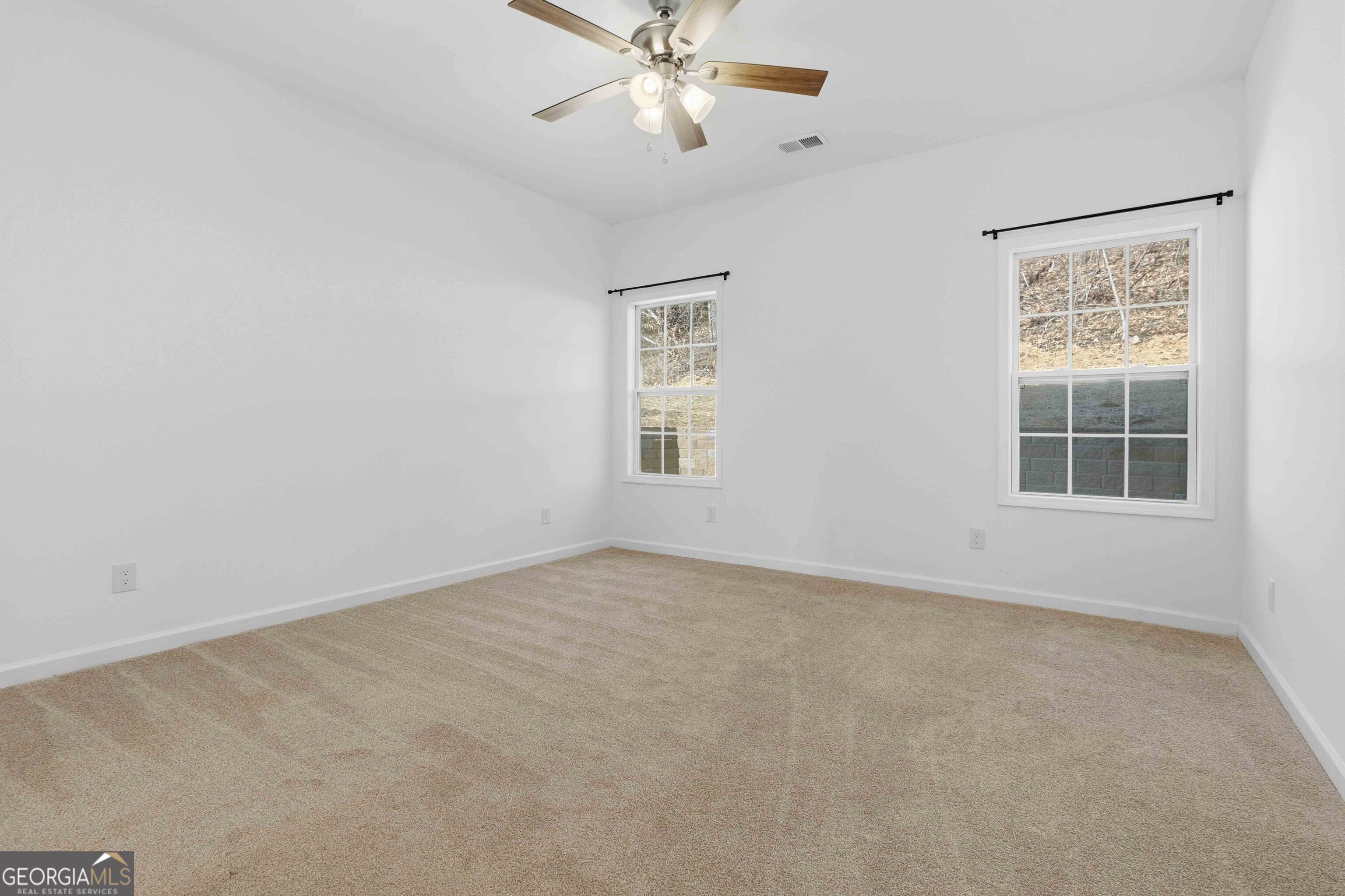 6938 Shadow Ridge Lane Stone Mountain, GA 30087 - Photo 26 of 27 an empty room with windows and fan