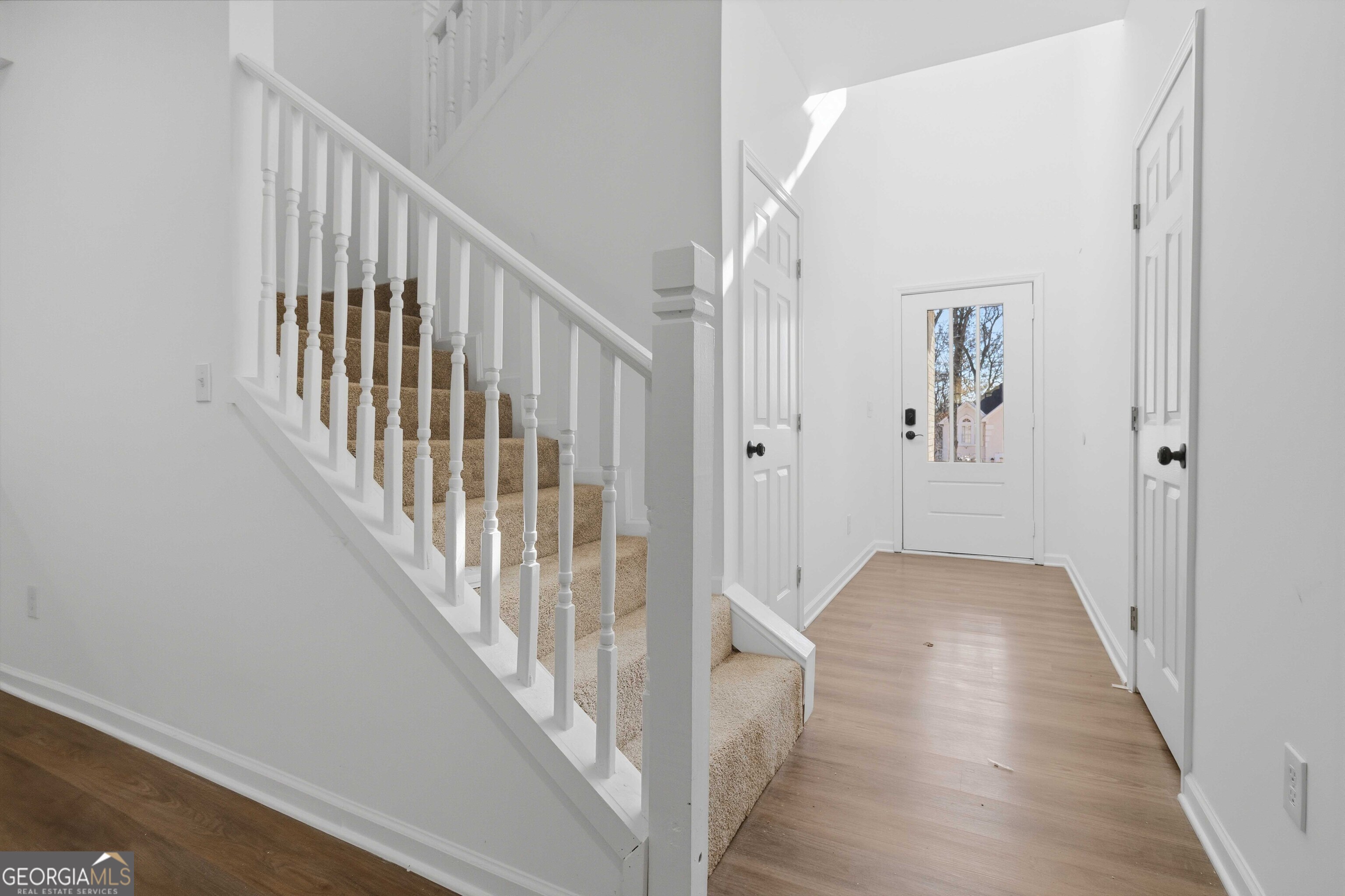 6938 Shadow Ridge Lane Stone Mountain, GA 30087 - Photo 5 of 27 a view of a hallway with wooden floor and staircase