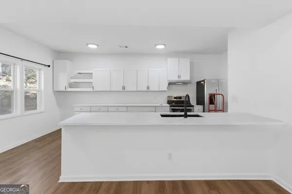 a view of kitchen with kitchen island white cabinets and refrigerator