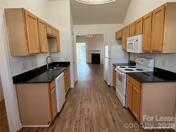 a kitchen with stainless steel appliances a sink a stove top oven a counter space and cabinets