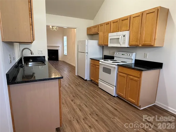 a kitchen with granite countertop a sink stove and refrigerator