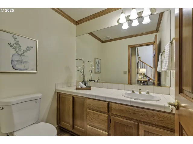 a bathroom with a sink a toilet and a mirror