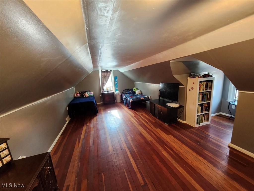 3205 Center Road Ashtabula, OH 44004 - Photo 21 of 29 Additional living space featuring built in shelves, dark wood-type flooring, and vaulted ceiling