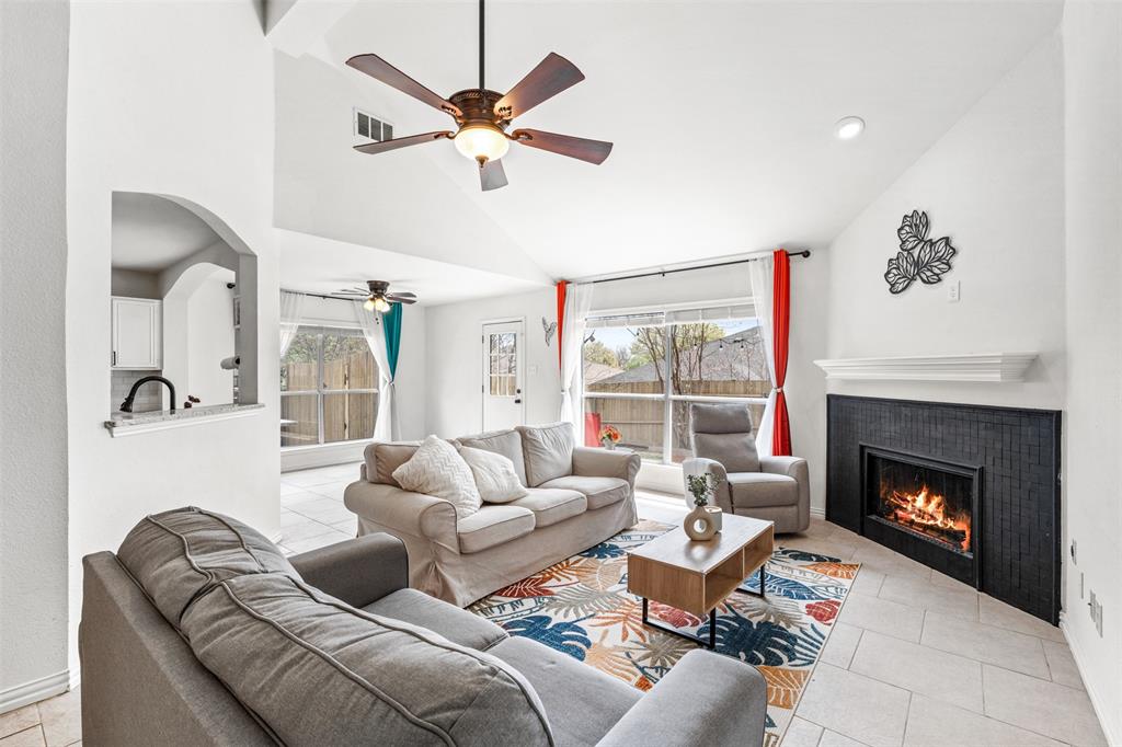 1011 Ridgecrest Drive McKinney, TX 75069 - Photo 7 of 31 Vaulted living area featuring a fireplace with a black tile surround and a white mantel