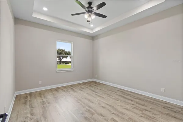 an empty room with a window and ceiling fan