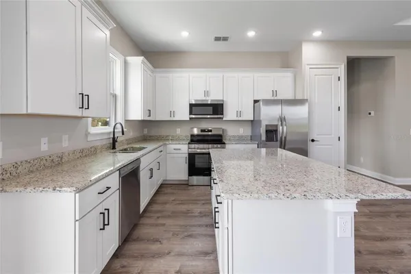 a kitchen with granite countertop a counter top space appliances cabinets and a counter space