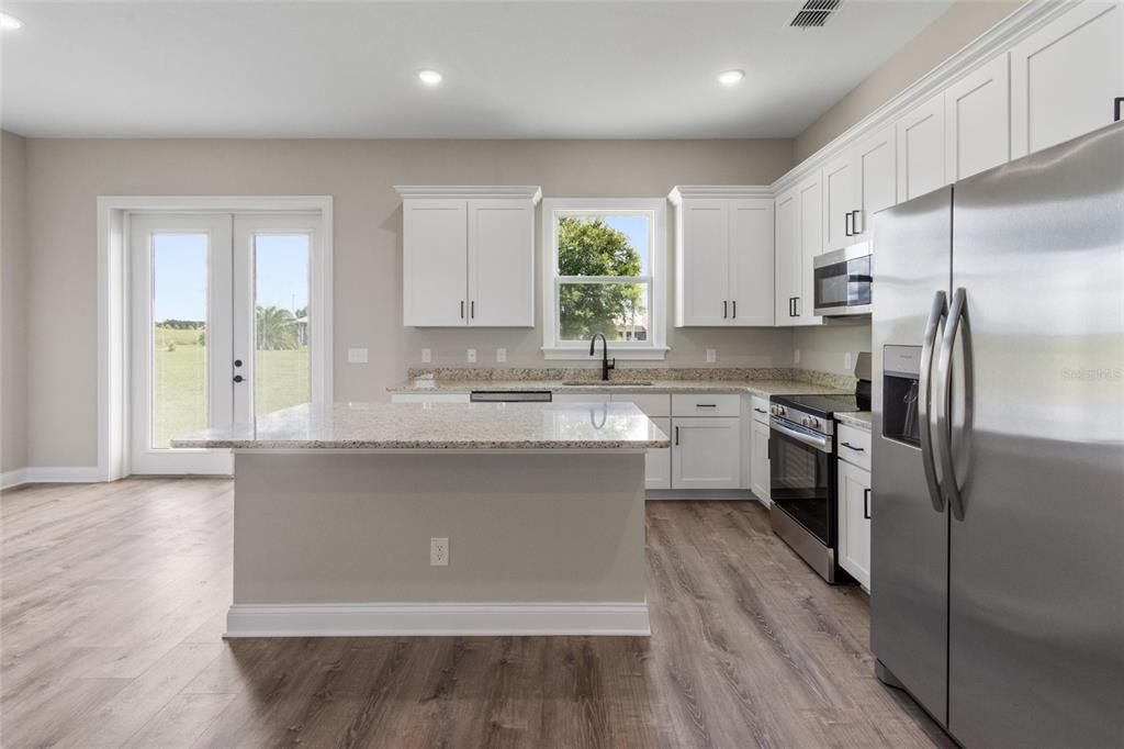 3620 Garrard Road Fort Meade, FL 33841 - Photo 4 of 33 a kitchen with a refrigerator a sink and wooden cabinets