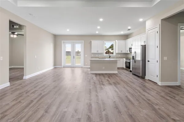 a view of kitchen with cabinets stainless steel appliances and wooden floor