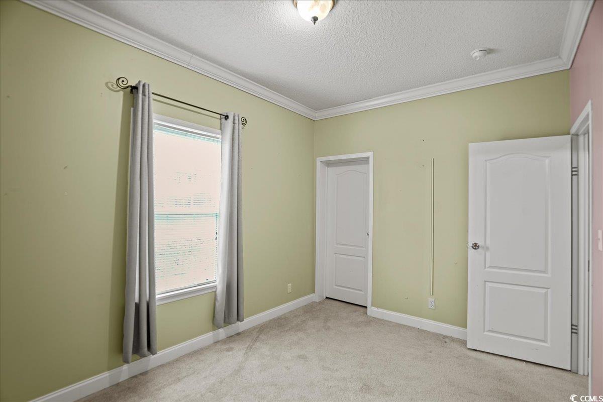 706 Beverly Hills Road Camden, SC 29020 - Photo 13 of 25 Unfurnished bedroom featuring light carpet, a textured ceiling, and ornamental molding