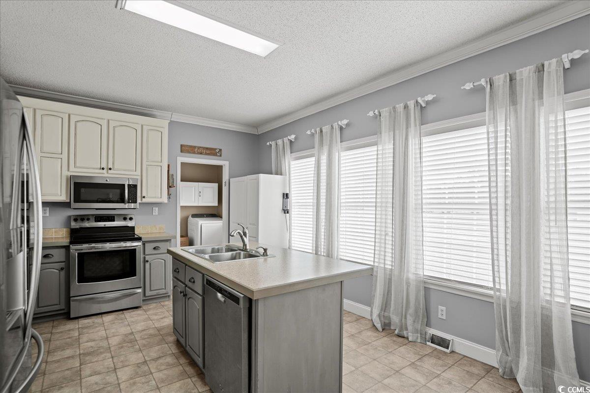 706 Beverly Hills Road Camden, SC 29020 - Photo 4 of 25 Kitchen featuring stainless steel appliances, light countertops, ornamental molding, gray cabinets, and a textured ceiling