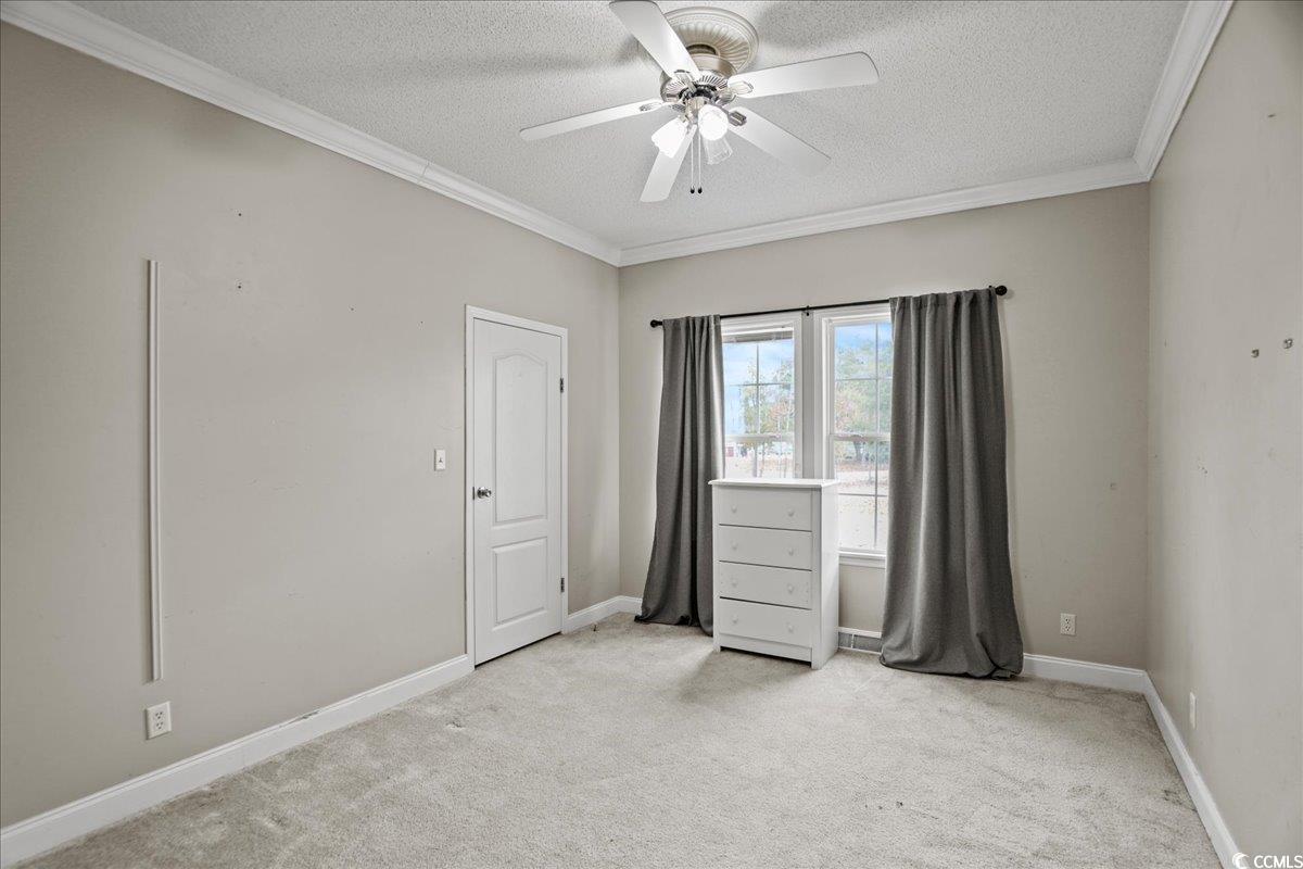 706 Beverly Hills Road Camden, SC 29020 - Photo 8 of 25 Spare room with light colored carpet, crown molding, a ceiling fan, and a textured ceiling
