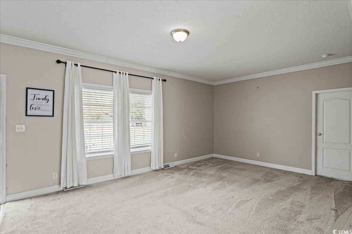 706 Beverly Hills Road Camden, SC 29020 - Photo 9 of 25 Empty room featuring a textured ceiling, crown molding, and light colored carpet