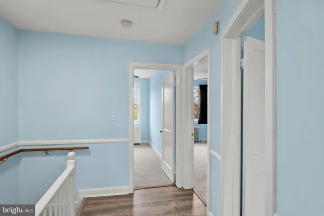 a view of a hallway with wooden floor and entryway