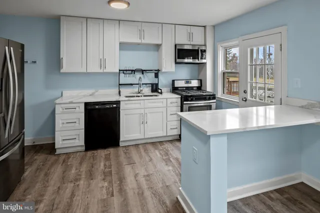 a view of a kitchen with a sink dishwasher and a stove top oven