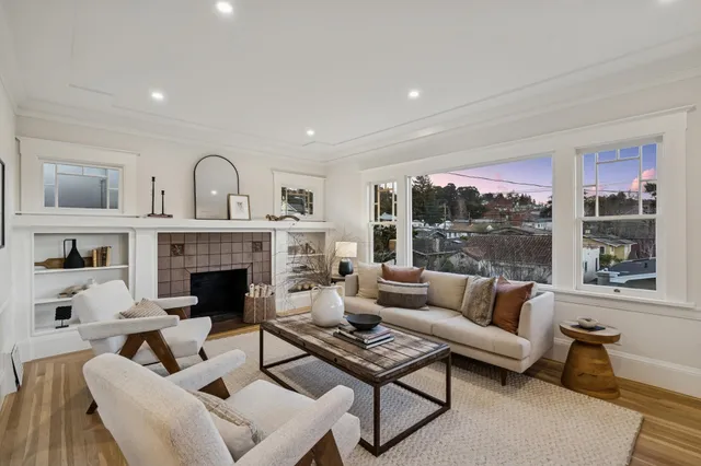 a view of a dining room and livingroom with furniture wooden floor a chandelier