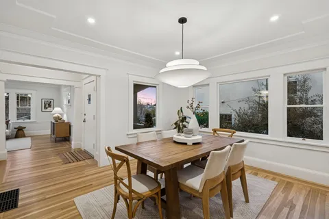 a view of a patio with table and chairs potted plants and large tree