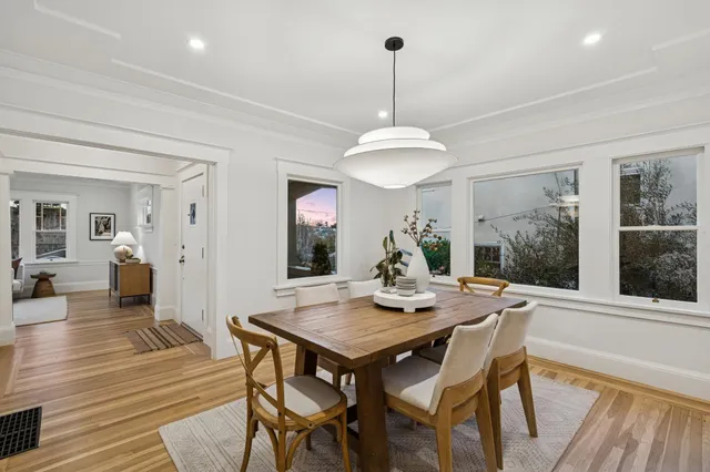 a view of a patio with table and chairs potted plants and large tree