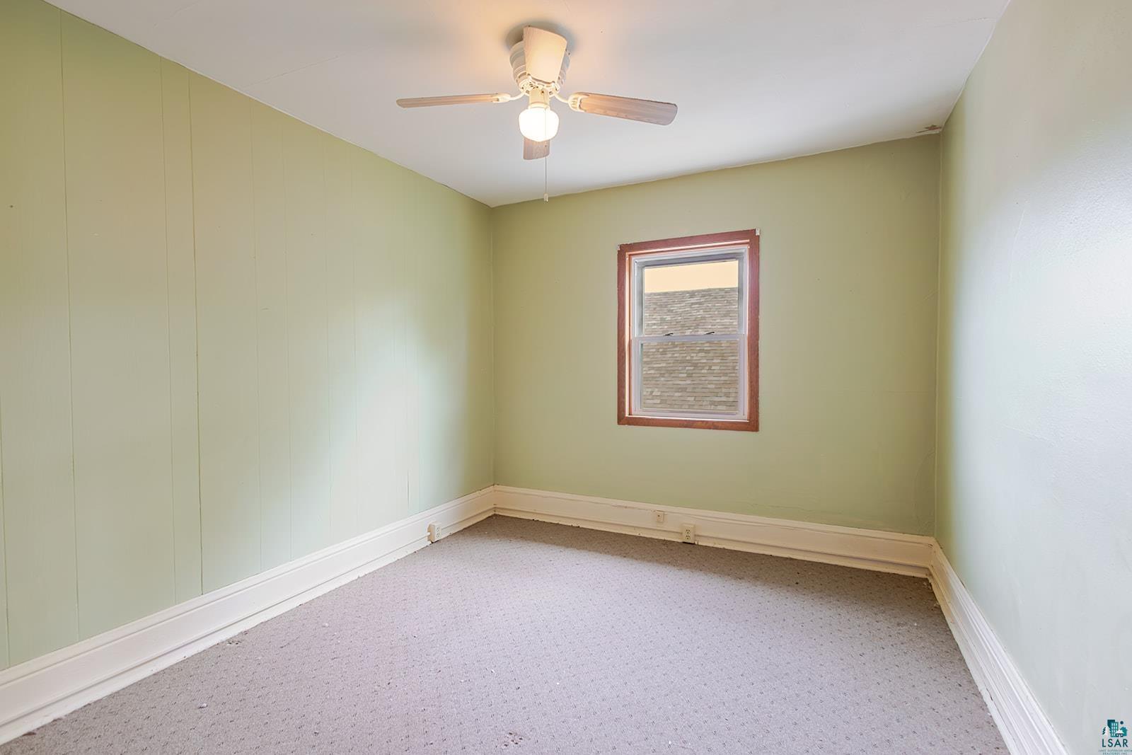 438 9th Street Cloquet, MN 55720 - Photo 19 of 27 Room featuring a single window with wood-finish trim, a ceiling fan with integrated lighting, and light green wall paneling