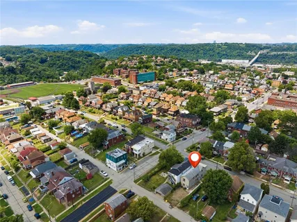 an aerial view of residential houses with outdoor space and trees