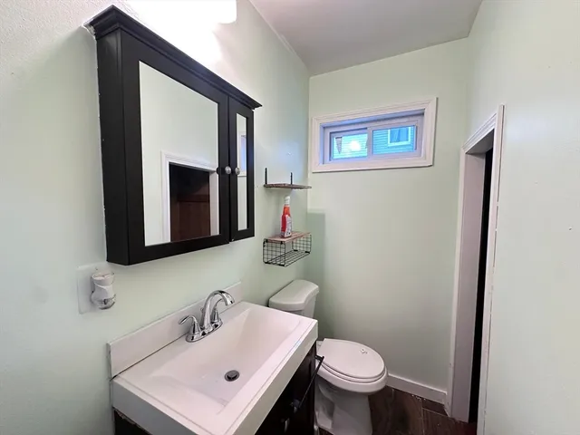 a bathroom with a toilet sink and mirror
