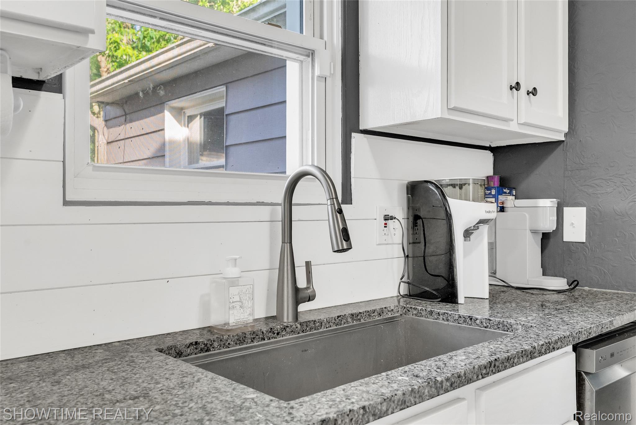3444 Maple Street Port Huron, MI 48060 - Photo 15 of 30 Stainless steel undermount sink with a gooseneck faucet, set within granite countertops